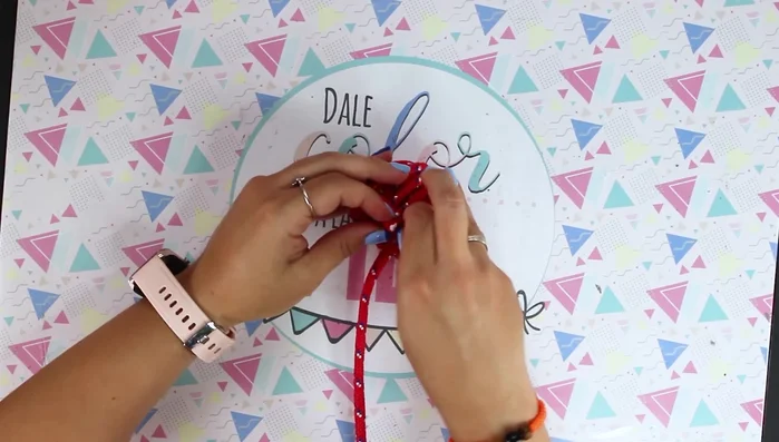 Cortar el sobrante de cuerda, quemar con un mechero para evitar que se deshilache y meter el extremo por la última cuerda para sujetarlo (385.27)