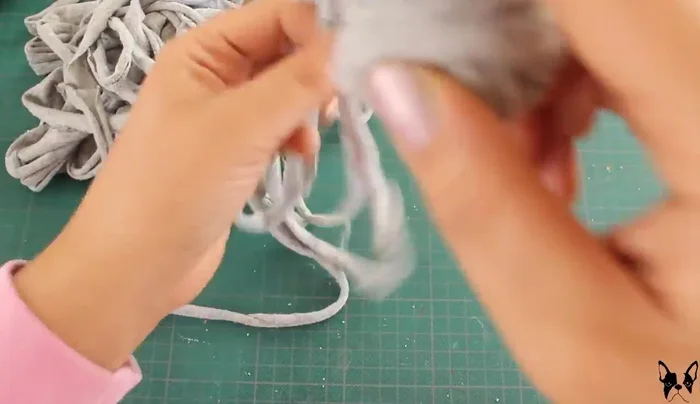 Haz una madeja con las tiras de trapillo.