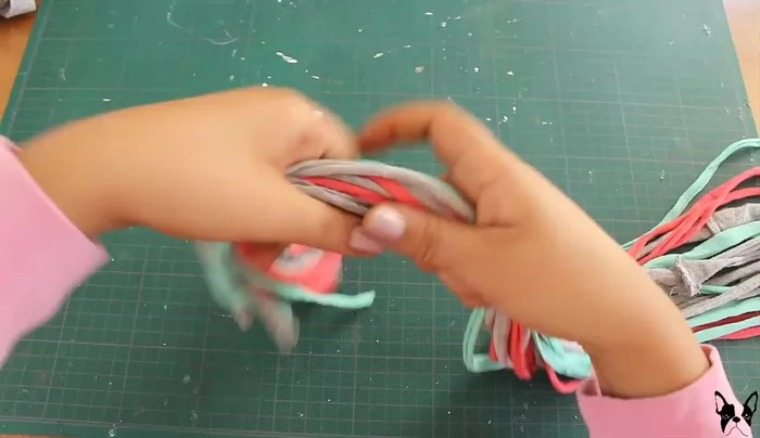 Haz un nudo dejando 10 cm libres. Esto permitirá que las tiras cuelguen y llamen la atención del perro.