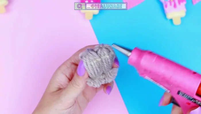 Pegar las patitas al cuerpo del perrito con silicona caliente.