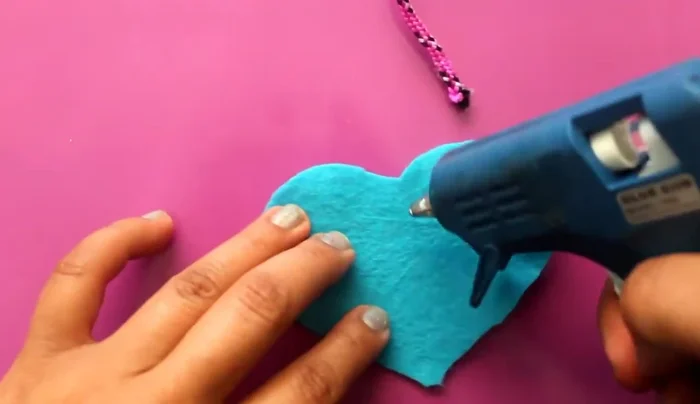 Agregar plumas: Aplica silicón en la parte inferior de la presa y pega plumas de diferentes colores.