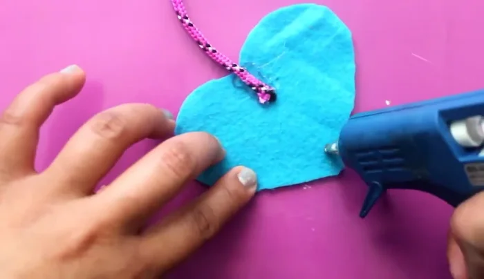 Agregar plumas: Aplica silicón en la parte inferior de la presa y pega plumas de diferentes colores.