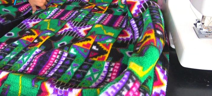 Cerrar la parte de las axilas y reducir el ancho de las mangas al ancho del puño con costuras rectas.