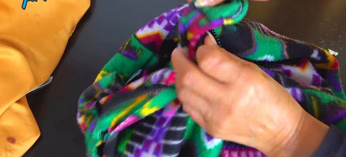 Desatar los cierres de la polera y desdoblar los dobleces de las mangas y el cuerpo.