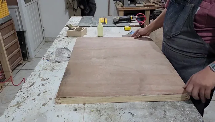 Cortar un pedazo de triplay de 6mm para la tapa de la base y clavarlo.