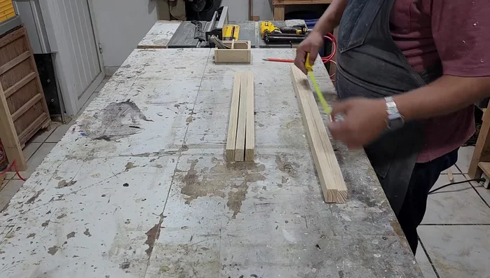 Cortar las piezas de madera. Se necesitan dos piezas de 80cm de largo para la base y tres piezas de 56cm de ancho para el interior (el ancho dependerá del tamaño del cojín).