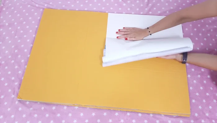 Dibujar y recortar una puerta en uno de los cartones. Forrar el suelo con vinilo.