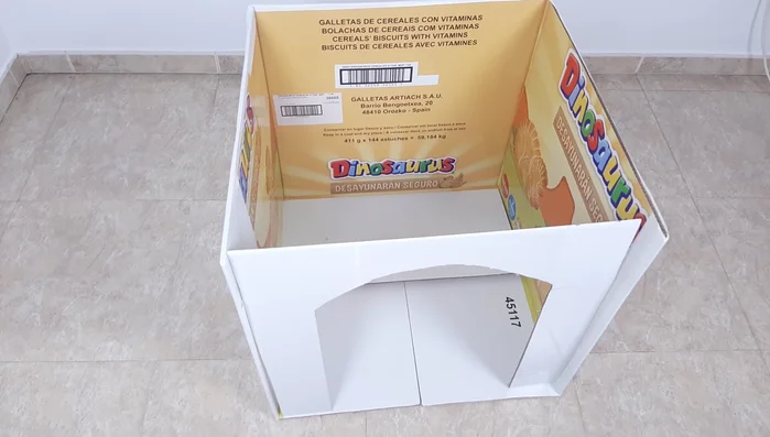 Dibujar y recortar una puerta en uno de los cartones. Forrar el suelo con vinilo.
