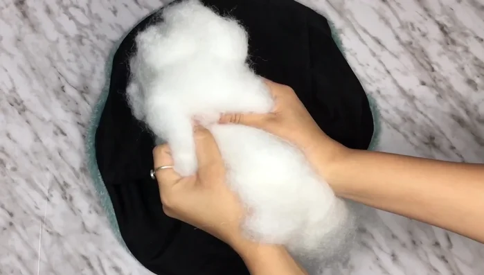 Rellenar: Introducir el relleno (napa o retazos) en el interior de la estructura de la dona hasta que quede bien firme.