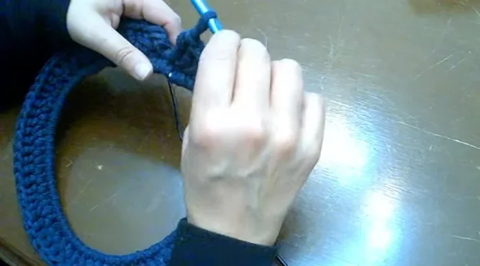 Cerrar el último punto alto cuidadosamente para ocultar la unión, siguiendo las instrucciones detalladas en el video (660).