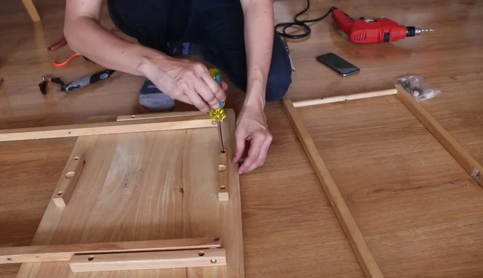 Unir las patas con la tira de madera usando tornillos.