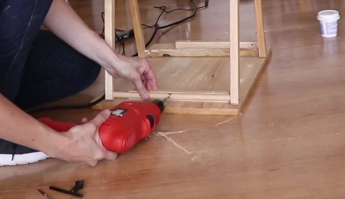 Colocar las patas sobre la mesita con la madera añadida y unirlas con tornillos.