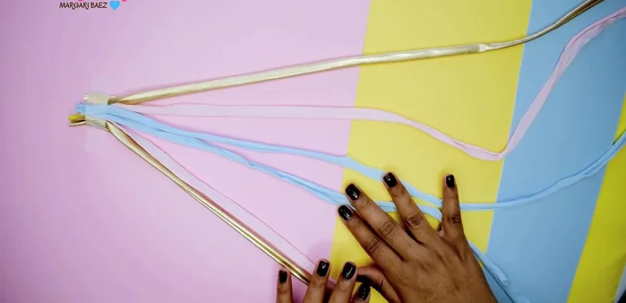 Preparar 6 cordones de trapillo (ordenar con un patrón: dorado, rosa, azul, dorado, rosa, azul).