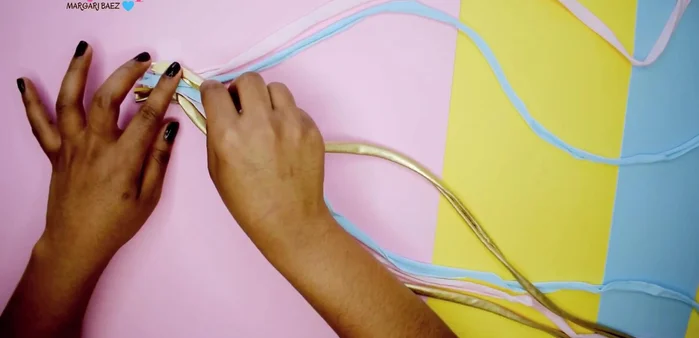 Continuar el trenzado, sujetando siempre la tela con el dedo para evitar que se deshaga.