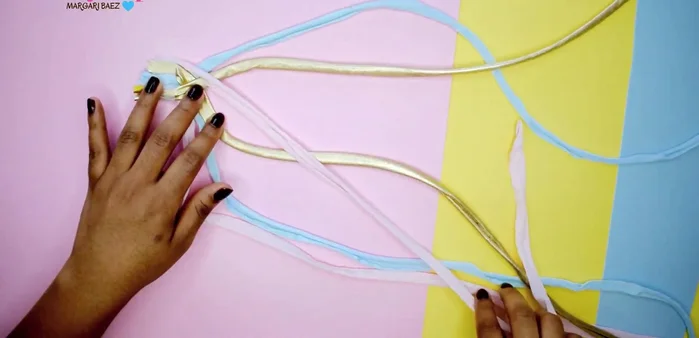 Continuar el trenzado, sujetando siempre la tela con el dedo para evitar que se deshaga.