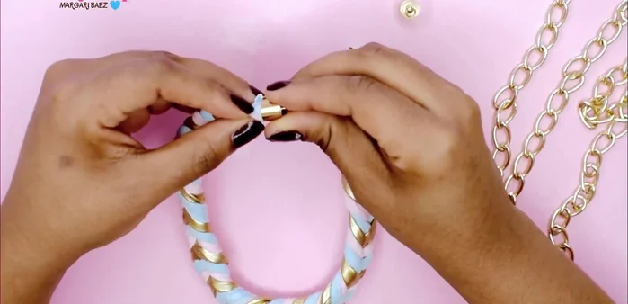 Colocar el cierre de joyería con pegamento, haciendo movimientos circulares para que la tela quede dentro. Asegurar con pegamento.