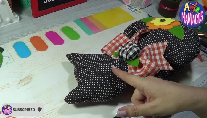 Pegar los ojos: Pegar los ojos plásticos (opcional) sobre una base de fieltro blanco para que resalten sobre la tela negra.