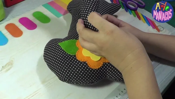 Colocar la cola: Coser o pegar la cola en la parte trasera del gato.