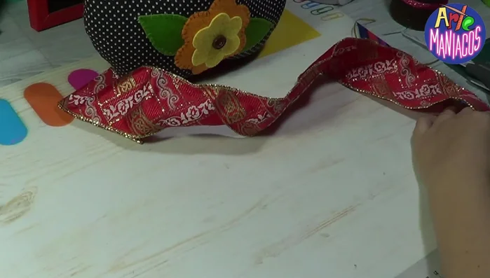 Pegar los ojos: Pegar los ojos plásticos (opcional) sobre una base de fieltro blanco para que resalten sobre la tela negra.