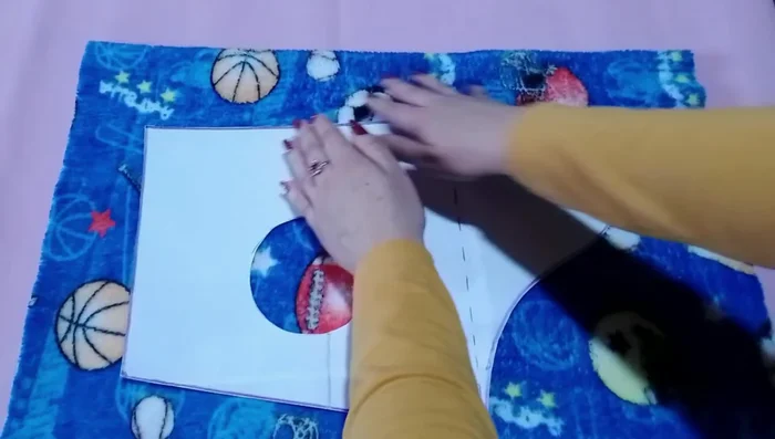 Cortar la tela: Doblar la tela por la mitad con el derecho hacia adentro. Colocar el patrón sobre la tela y asegurar con alfileres. Recortar dejando un pequeño margen para la costura si se desea un abrigo más suelto.