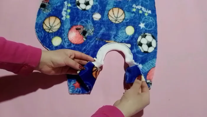 Unir las partes laterales del abrigo: Cose las dos partes laterales del abrigo, realizando posteriormente una costura en zigzag para reforzar.