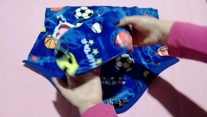 Unir la capucha al abrigo: Colocar la capucha sobre el abrigo, asegurándose de que esté centrada. Unir con alfileres y coser, realizando una costura en zigzag para asegurar.