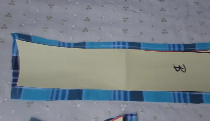 Cortar la tela según el molde. Dejar 1 cm de margen de costura en los bordes y 4 cm en la zona del pecho para el dobladillo.