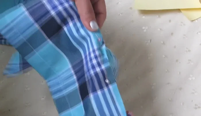 Coser las mangas a la camisa. Colocar alfileres a 1 cm del borde de la tela y coser.