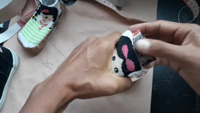 Coser la tira al calcetín del bebé alrededor del borde. Se puede usar hilo normal o hilo de zapatero para mejor estética.