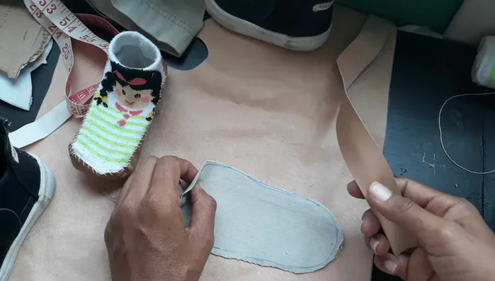 Cortar dos tiras de polipiel o vinilo de 2.5 cm de ancho. Se puede usar tela reciclada (como la bastilla de un pantalón).