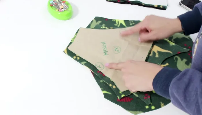 Inserción de las mangas: Une las mangas raglán (con las marcas de delantero y espalda correctamente alineadas) a las sisas correspondientes. Cose con hilo o broches para el cierre delantero.