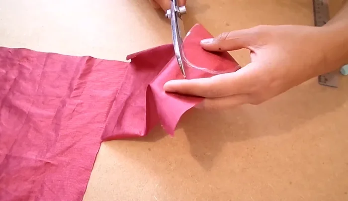 Seguir el contorno de un óvalo con la tela para medir la longitud necesaria para las tiras. Señalar con tiza, dejando 0.5 cm extra. Recortar cuatro tiras de 3 cm de ancho.