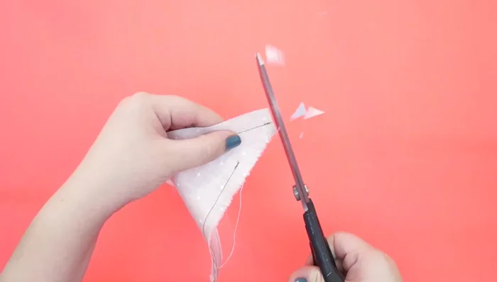 Recorta las esquinas y dale la vuelta al pañuelo. Usa un voltea-telas, un hilo con una aguja o un alfiler de seguridad para facilitar el proceso.