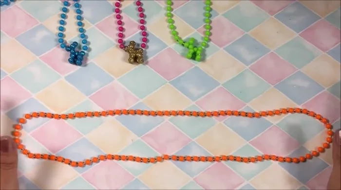 Encontrar la unión de los dos globos del collar.