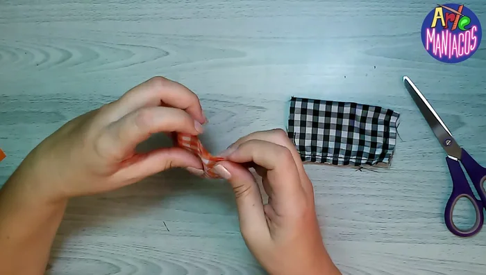 Zurcir el centro del moño con aguja e hilo para darle forma (o simplemente colocar la cinta directamente).