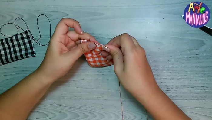 Zurcir el centro del moño con aguja e hilo para darle forma (o simplemente colocar la cinta directamente).