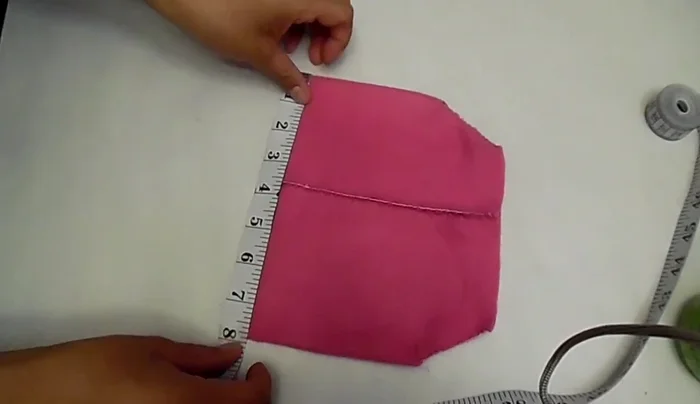 Coser el rectángulo negro al chaleco, haciendo pequeños dobleces a lo largo del borde para formar la falda. (Los dobleces deben estar separados aproximadamente una pulgada).