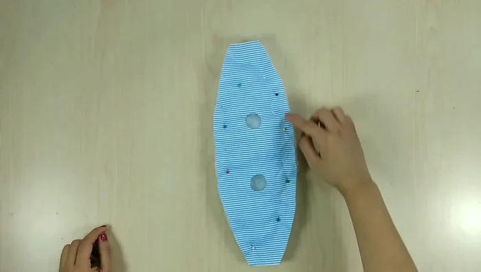 Coser las piezas: Colocar la otra pieza de tela sobre la guata y coser alrededor de todo el contorno, incluyendo los círculos. Recortar el exceso de tela.