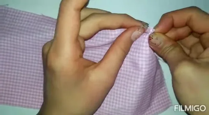 Fruncir la falda: Con hilo y aguja, fruncir la tira de tela para que se ajuste a la cintura del vestido.