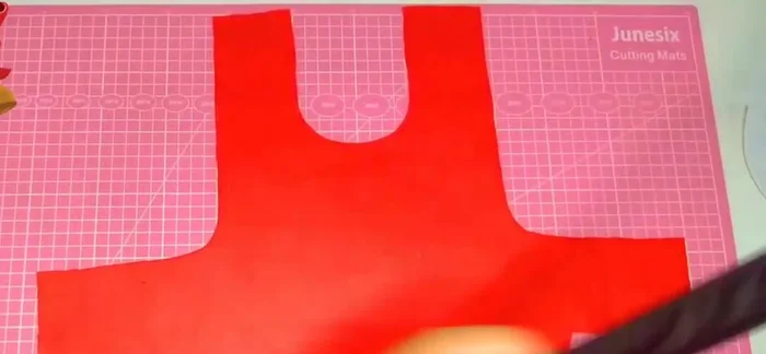 Colocar el cuello a la capa, sujetando con alfileres.