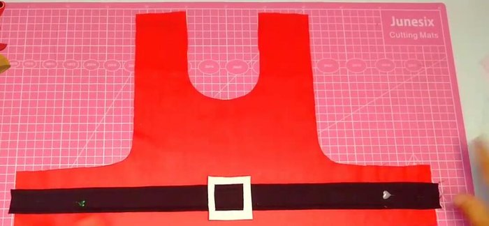 Colocar el cuello a la capa, sujetando con alfileres.