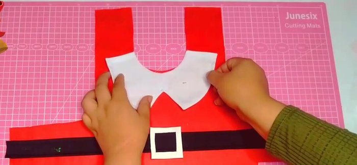 Colocar el cuello a la capa, sujetando con alfileres.