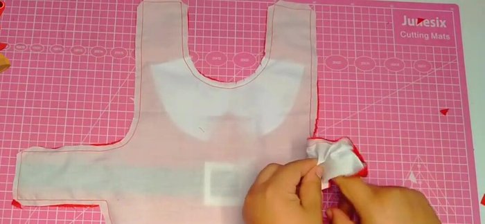 Coser la tira hasta el punto indicado en la capa para asegurarla.