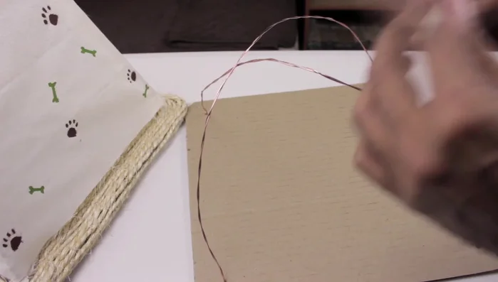 Pegar la unión de los dos alambres en la parte superior con cinta de papel.