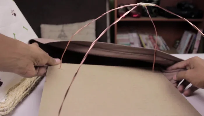 Introducir la estructura dentro de la playera y pegar la tela sobrante por debajo de la base con silicón o cinta.