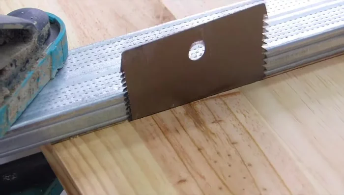 Crear la puerta de la casa cortando una pieza de madera y añadiendo un detalle de cara de gato.