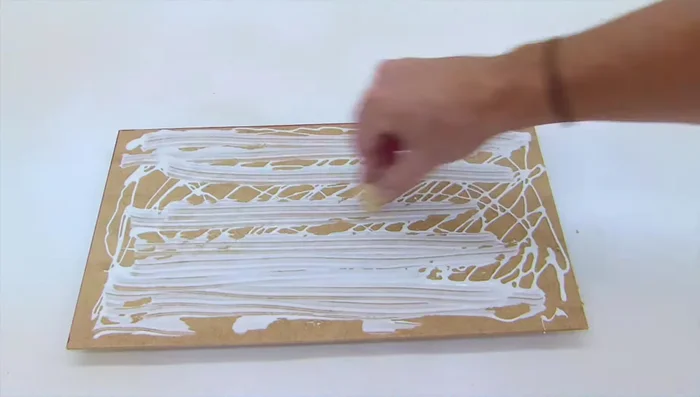 Crear un cojín para el interior de la casa usando una camiseta vieja y pegamento para tejidos.