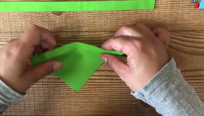 Hacer un pequeño doblez en la parte superior del triángulo y plancharlo.