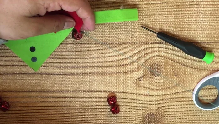 Coser los cascabeles al fieltro rojo.