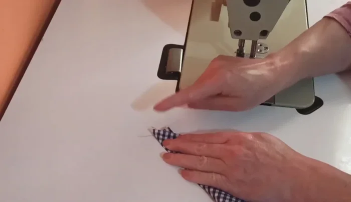 Coser las tres partes (las dos tiras y el cuadrado) juntas.